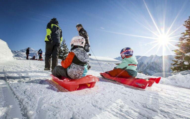 Kinder beim Schlitteln im Winter