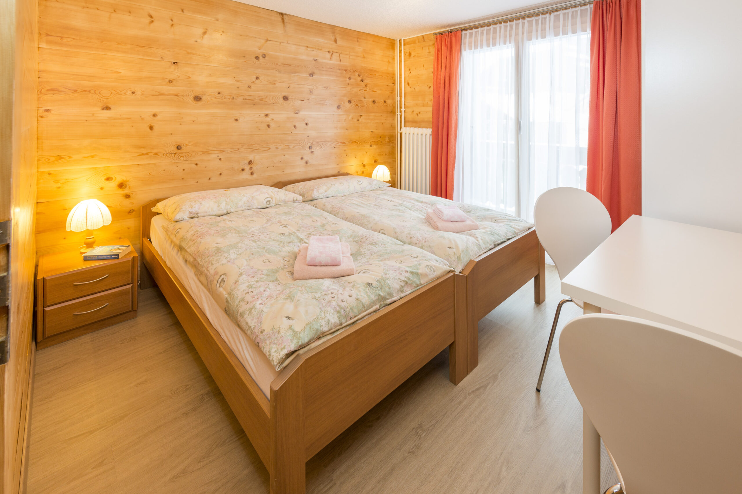 Helles Schlafzimmer mit Balkonzugang im Chalet Miranda