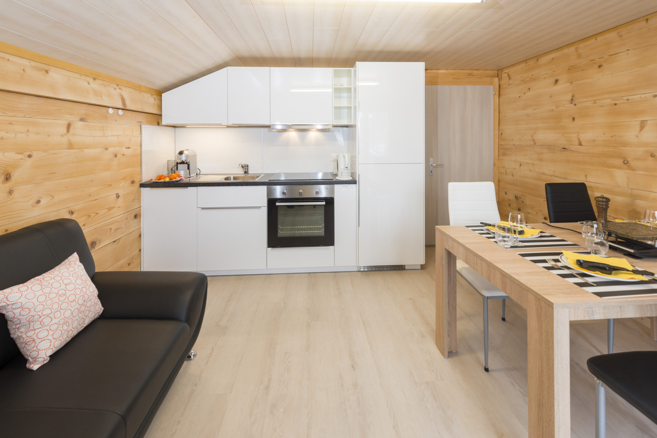 Wohnzimmer mit offener Küche und Sofa im Chalet Miranda