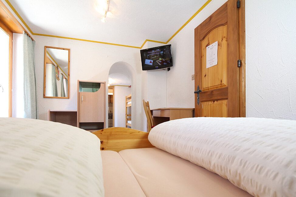 Familienzimmer mit Holzeinrichtung im Hotel Alpina
