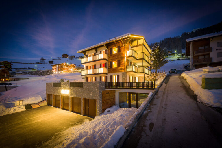 Haus Lunic in Grächen am Winterabend von außen